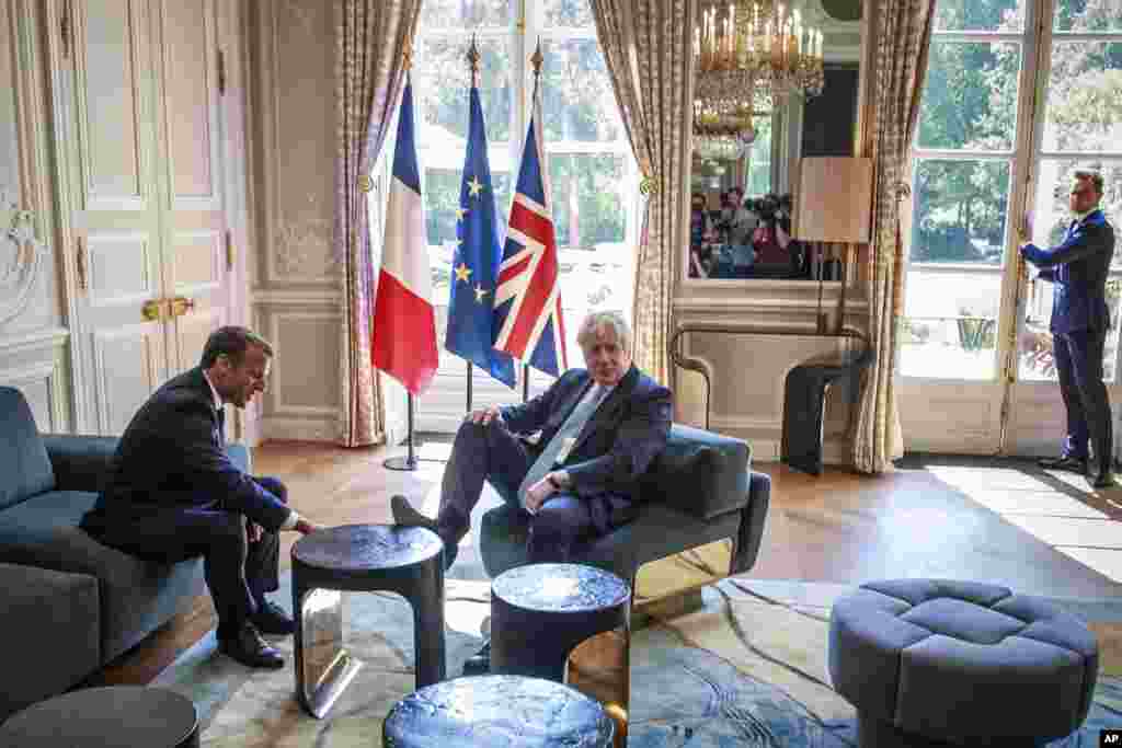 French President Emmanuel Macron, left, talks to Britain's Prime Minister Boris Johnson during their meeting at the Elysee Palace in Paris.
