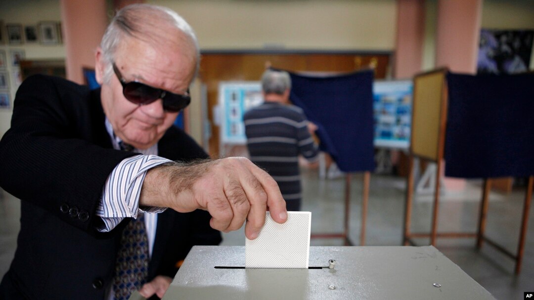 A man votes in the presidential election in southern port city of Limassol, Cyprus, February 24, 2013. 
