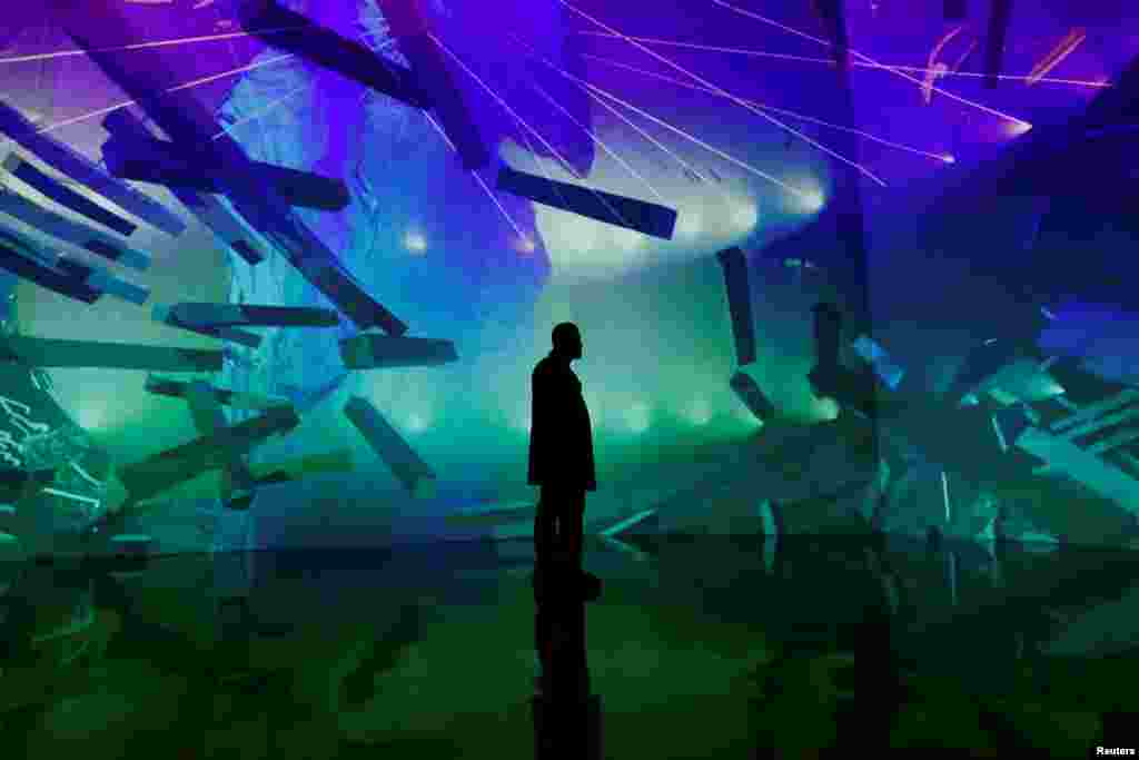 A man stands in front of a 'Lucid Motion' exhibition at Artechouse in Washington, Nov. 17, 2019.