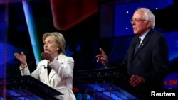 Ứng cử viên tổng thống đảng Dân chủ Hillary Clinton (trái) và Thượng nghị sĩ Bernie Sanders phát biểu đồng thời trong một cuộc tranh luận được tổ chức bởi CNN và New York One tại Brooklyn Navy Yard, New York ngày 14 tháng 4 năm 2016.