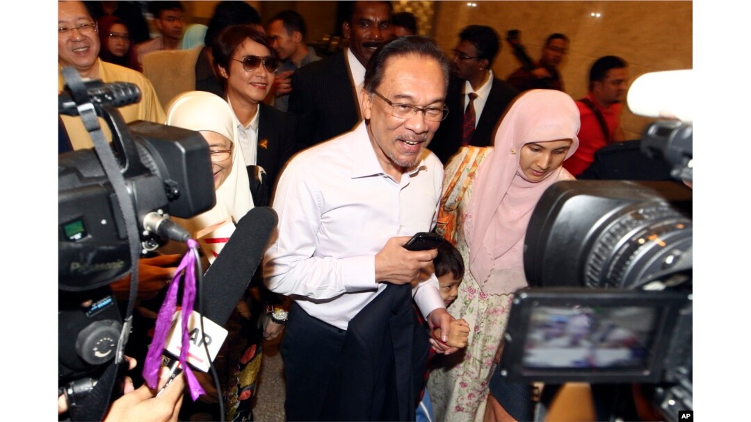 FILE -Malaysian opposition leader Anwar Ibrahim, center, arrives at court house in Putrajaya, Malaysia, Feb. 10, 2015.