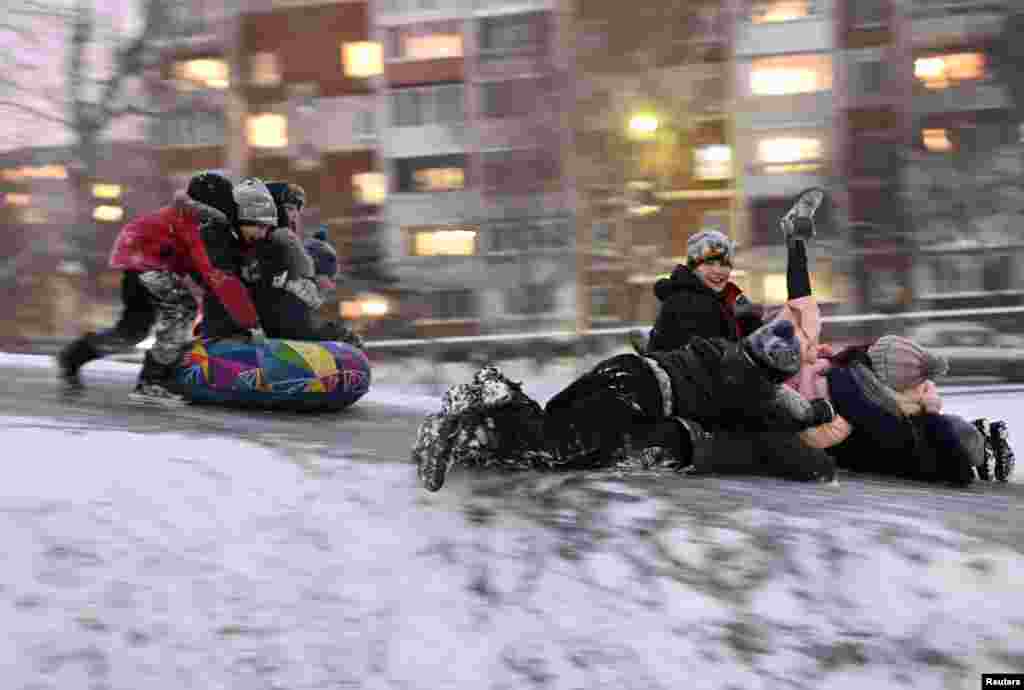 Children slide down an ice-covered slope in Omsk, Russia.
