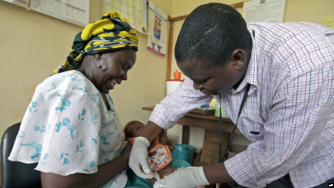 Iren Salama (L) holds her baby Pendo as it is given an injection as part of a malaria vaccine trial at a clinic in the Kenya coastal town of Kilifi, November 23, 2010 (file photo)