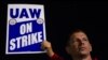 Miembros del sindicato de trabajadores automotrices UAW levantan un cartel en una huelga en una planta de Ford, en Wayne, Michigan, el 15 de septiembre de 2023.