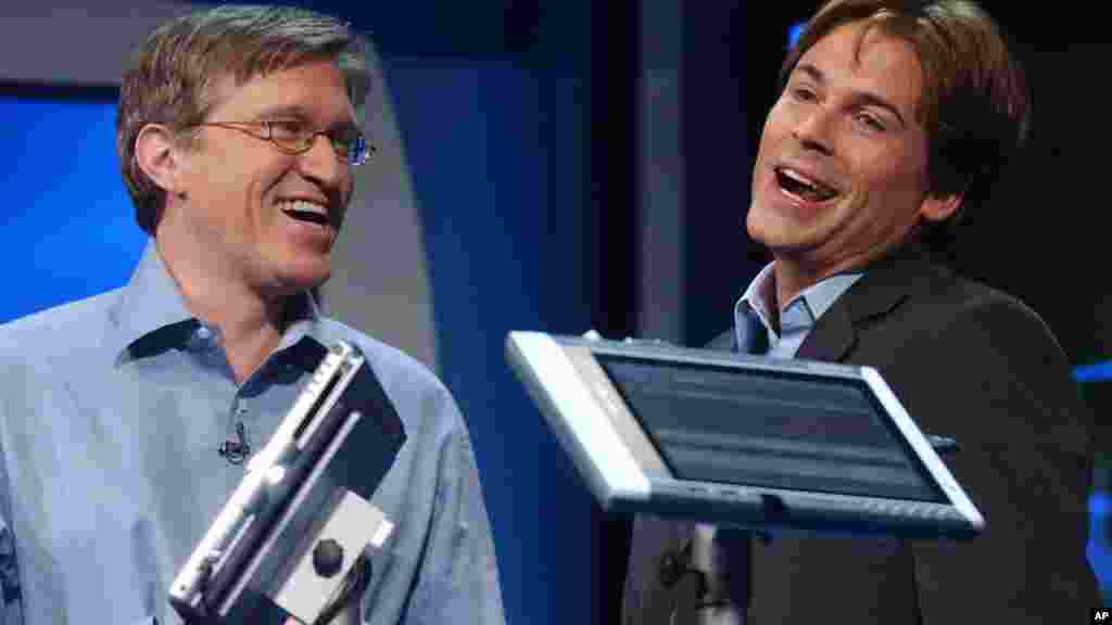 Jeff Raikes, group vice president of the Productivity and Business Systems Group at Microsoft (L) jokes with Actor Rob Lowe, as he describes his experiences using a Tablet PC at the product launch event in New York City, Nov. 7, 2002.