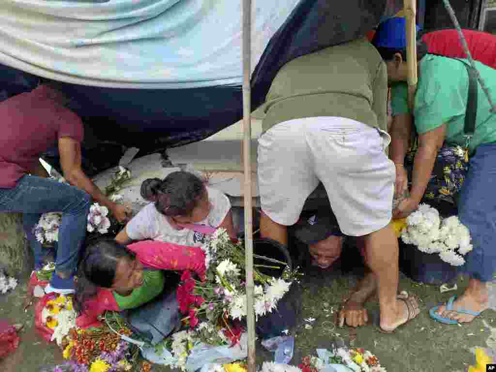 Trapped flower vendors are pulled out from a collapsed wall following an earthquake that struck Padada, Davao del Sur province, southern Philippines.