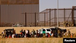 Migrantes son detenidos por agentes de la Patrulla Fronteriza de EEUU, después de cruzar el río Bravo para entregarse a solicitar asilo en El Paso, Texas, visto desde Ciudad Juárez, México, 29 de marzo de 2023.