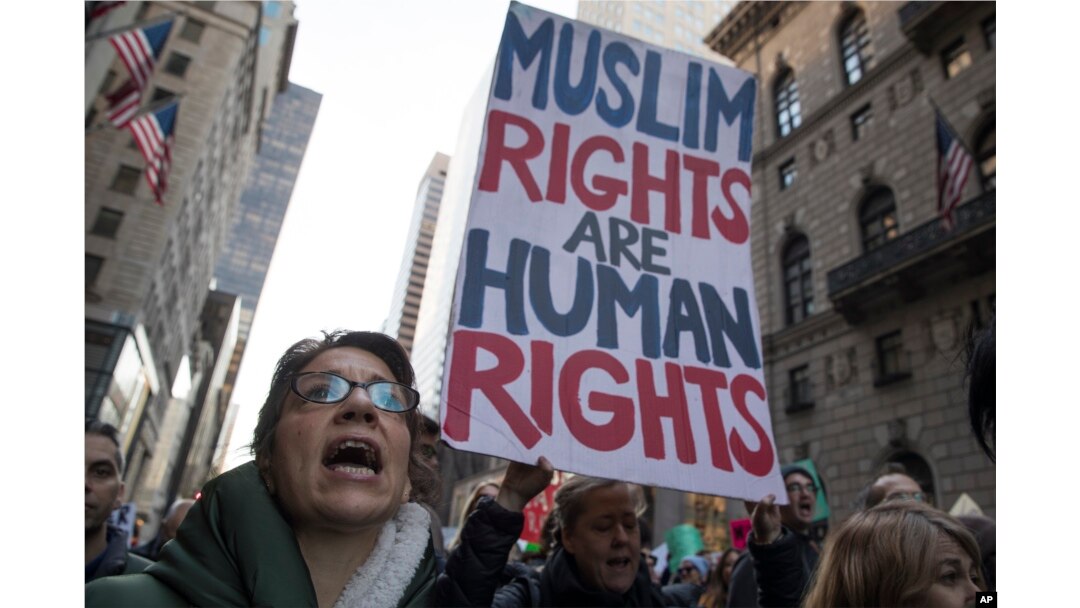 A demonstrator holds a sign during a rally outside Trump Tower in New York on Saturday, Nov. 12, 2016, to protest against President-elect Donald Trump.