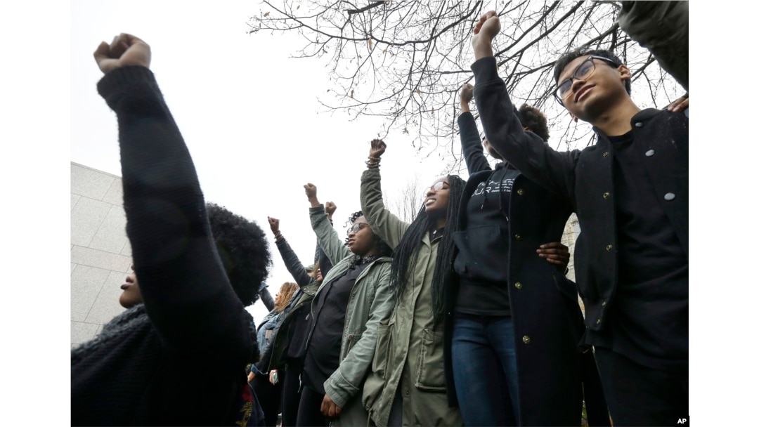 FILE - Students at Boston College raise their arms during a solidarity demonstration on the school's campus, Thursday, Nov. 12, 2015, in Newton, Mass.