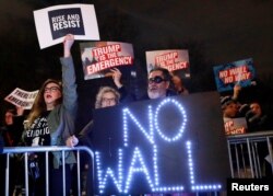 FILE - People gather during a protest against U.S. President Donald Trump's declaration of a national emergency to build a border wall, outside Trump International Hotel & Tower in Manhattan, New York.