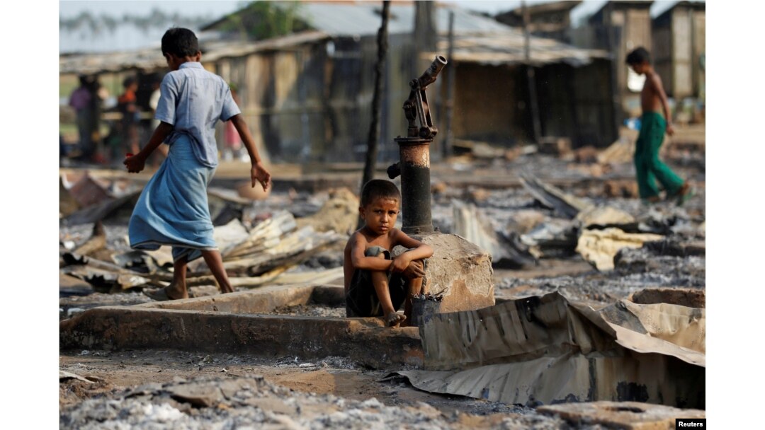FILE - A boy sits in a burned area after fire destroyed shelters at a camp for internally displaced Rohingya Muslims in western Rakhine State near Sittwe, Myanmar, May 3, 2016.