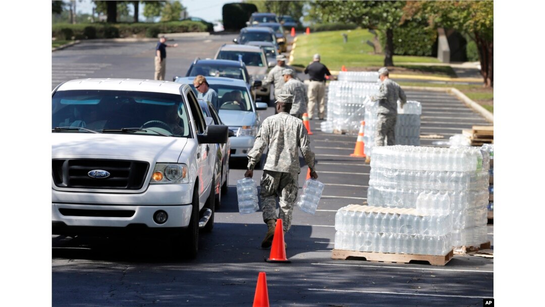 National Guard members hand out water to residents in Columbia, S.C., Oct. 6, 2015. Water distribution remained a key problem Tuesday across much of the state.