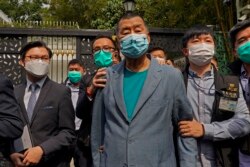 Hong Kong media tycoon Jimmy Lai, center, who founded the Apple Daily, is arrested by police officers at his home in Hong Kong on April 18, 2020. (Associated Press)