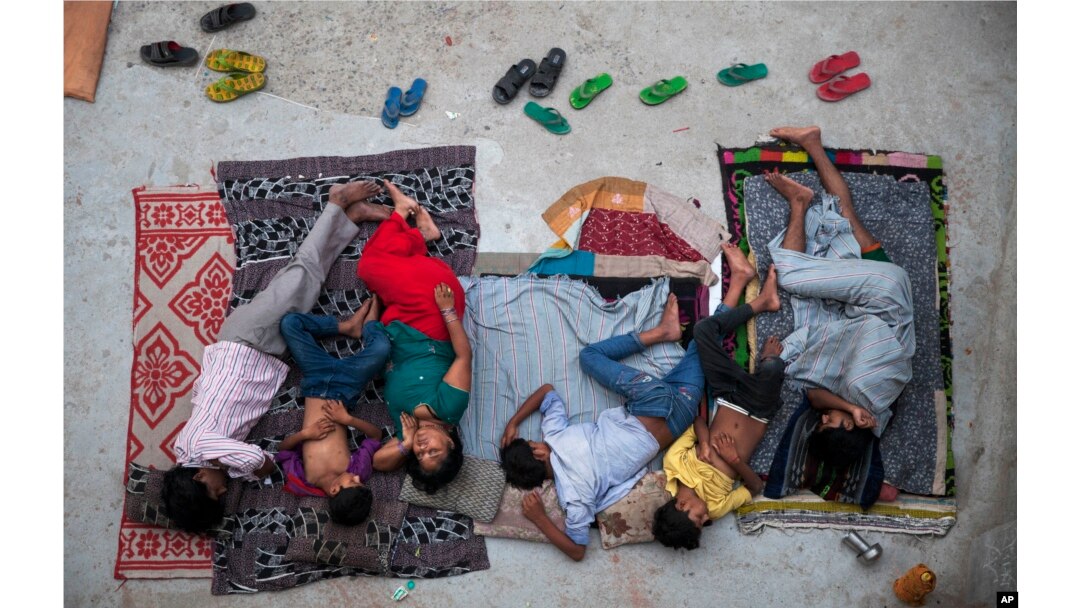 FILE - An Indian family sleeps on the roof of a house to beat the heat in New Delhi, India, May 29, 2015.
