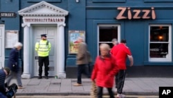 Police outside an Italian restaurant in Salisbury, England, March 6, 2018, near where former Russian spy double agent Sergei Skripal and his companion were found critically ill Sunday following exposure to an "unknown substance." Skripal, 66, and unidentified woman companion are being treated in hospital, after they were found unconscious on a park bench in Salisbury.