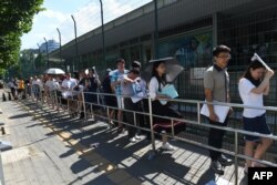 FILE - People line up for visa applications outside the US embassy in Beijing on July 26, 2018.