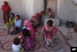 FILE - In this May 30, 2016 photo, Afghan internally displaced family are seen at their temporary home in a camp for internally displaced people in Kabul, Afghanistan.