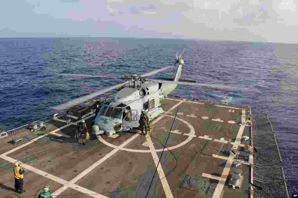 Trực thăng của Hải quân Mỹ trên tàu USS Pinckney đổi phi hành đoàn trước khi lên đường để tiếp tục tìm kiếm chiếc máy bay Malaysia mất tích.