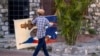 A man carries a painting of slain President Jovenel Moise in the Petion-Ville neighborhood in Port-au-Prince, Haiti, July 16, 2021.