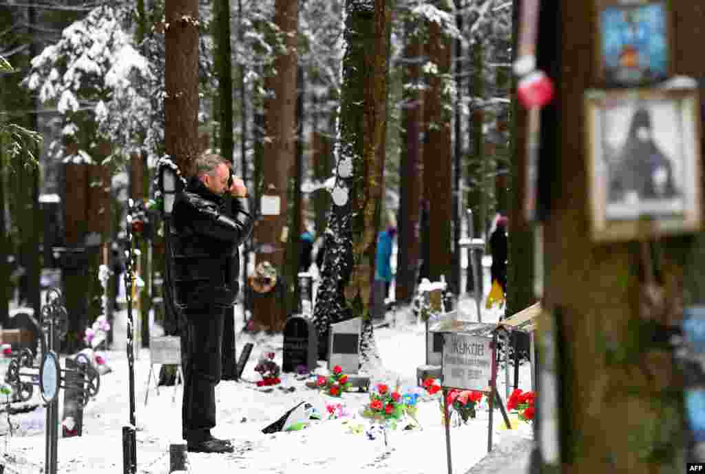 A man crosses himself at the memorial, where the victims of Soviet dictator Joseph Stalin's regime were buried in the woods on the outskirts of Saint Petersburg.