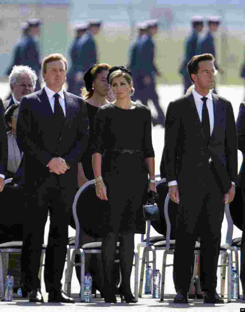 Vua Willem-Alexander (trái) cùng Hoàng hậu Maxima và Thủ tướng Mark Rutte, dành một phút mặc niệm trong buổi lễ tang tiếp nhận các thi hài đầu tiên của hành khách và phi hành đoàn trên chuyến bay MH17 của hãng Hàng không Malaysia.