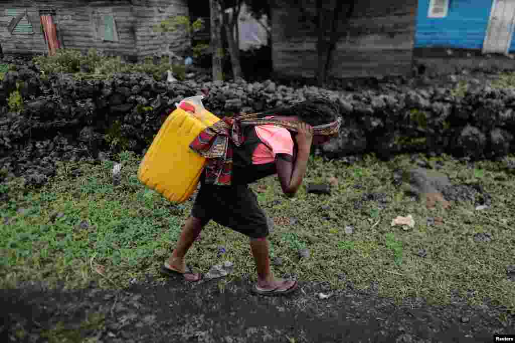 Chikuru, 11, carries water on her back in Bugamba district in Goma, the capital of North Kivu, eastern Democratic Republic of Congo, Sept. 30, 2019.