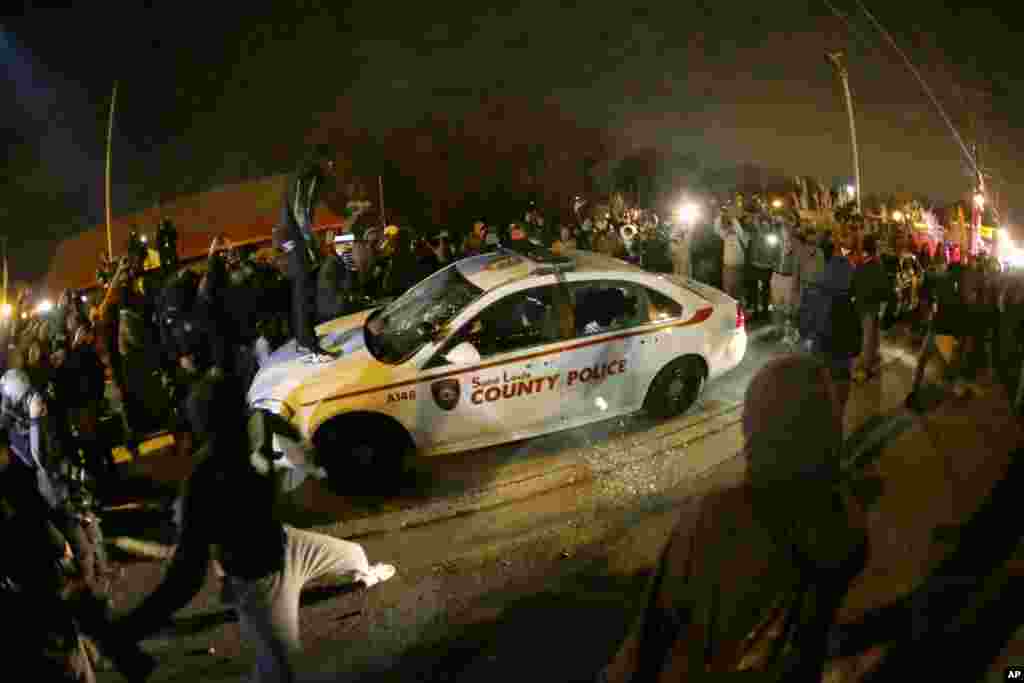 Um carro da polícia é rodeado por populares depois de um Grande Júri ter decidido não acusar o agente da polícia Darren Wilson na morte de Michael Brown. Ferguson, Missouri, Nov 24, 2014