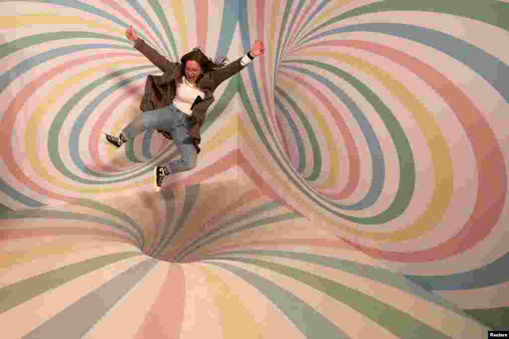 A girl poses for a photo during a visit to the Instagram museum "Smile Safari" that recently opened in Brussels, Belgium.