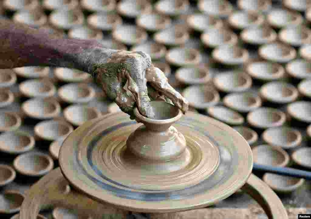 A man makes earthen lamps for Diwali, the Hindu festival of lights, at a workshop in Ahmedabad, India.
