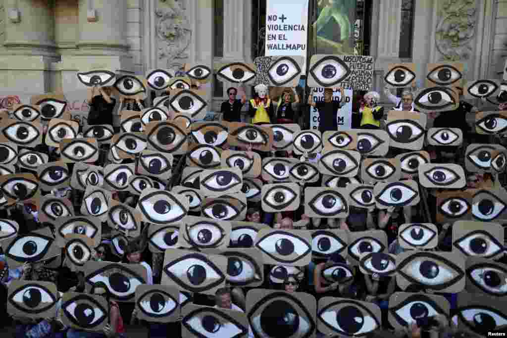 Demonstrators hold placards during a protest against Chile's government, in Santiago, Dec. 10, 2019.