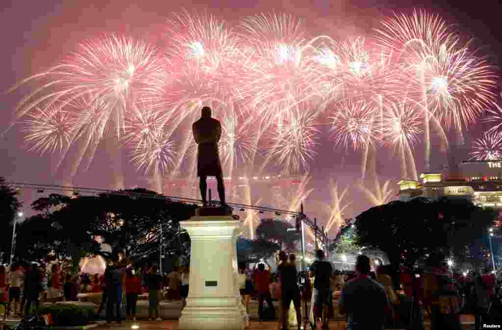 A statue of Sir Stamford Raffles is seen as spectators watch fireworks explode during Singapore's 54th National Day Parade in Singapore.