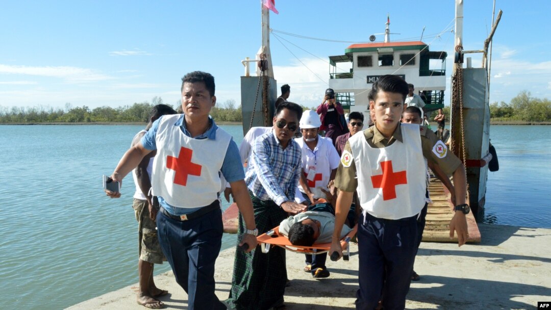 FILE - Injured people from Kyauk Tan village in Rathedaung township are carried on stretchers as they arrive in Rakhine state's capital Sittwe in western Myanmar, May 2, 2019.