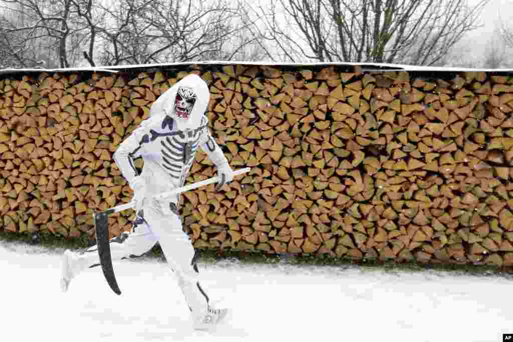A reveler depicting a grim reaper runs during a traditional St. Nicholas procession in the village of Valasska Polanka, Czech Republic, Dec. 7, 2019.