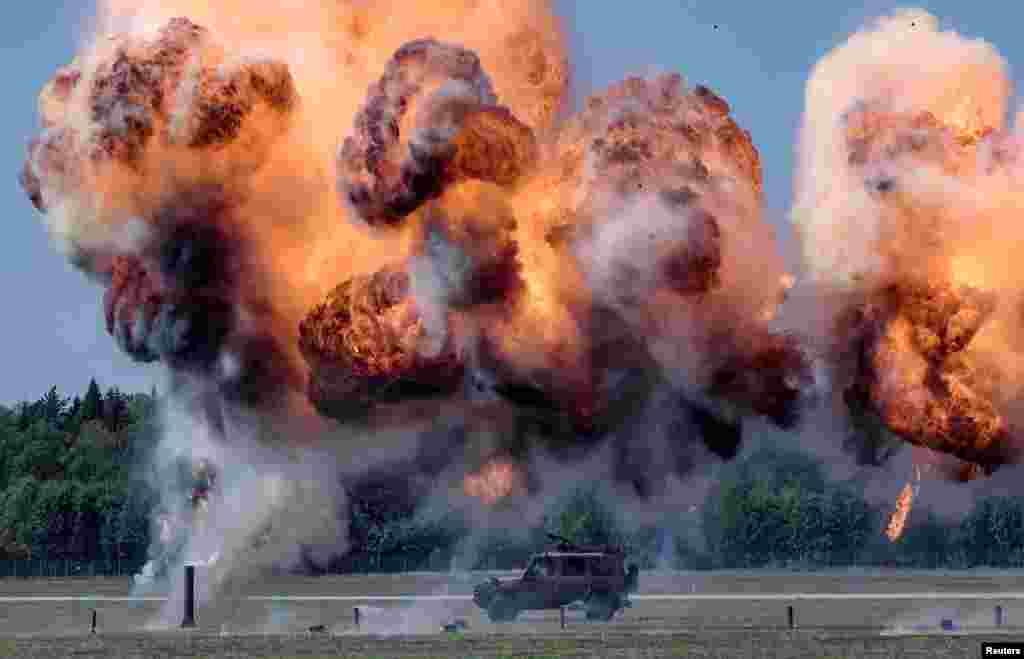 A jeep is straddled by bombs in a simulated air attack during the annual airforce Air Show at Kallinge airforce base near Ronneby, Sweden, Aug. 25, 2019.