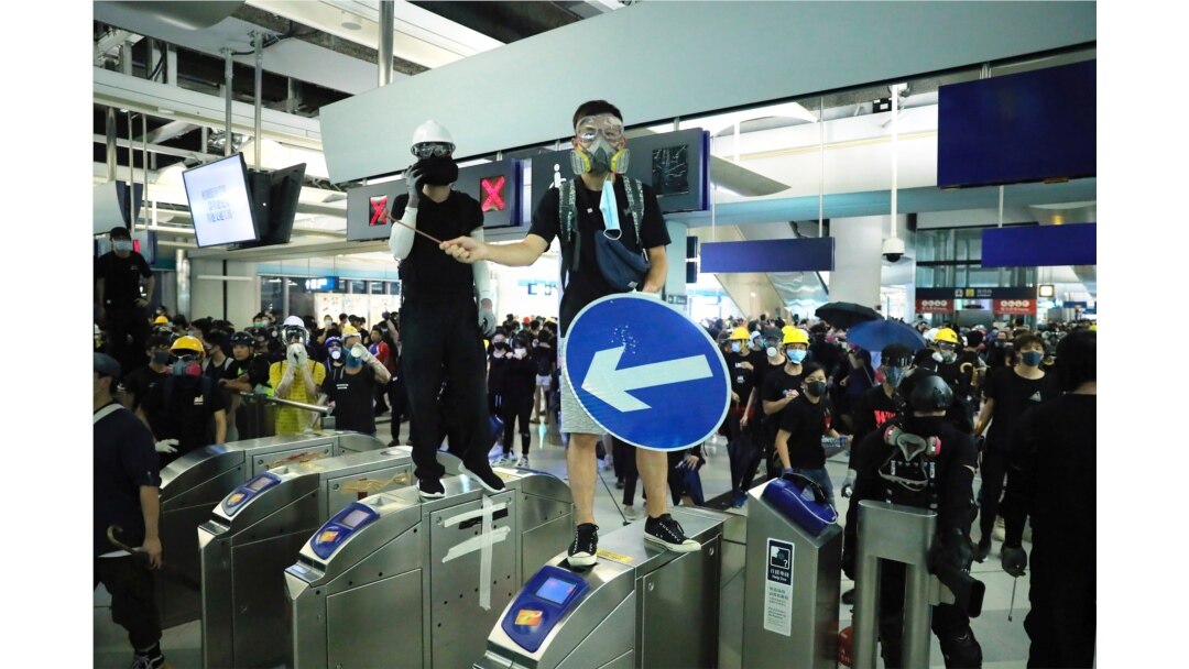 FILE - Demonstrators stand on turnstiles during a protest at the Yuen Long MTR station in Hong Kong, August 21, 2019.