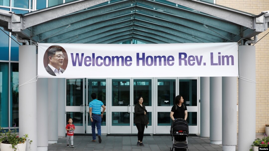 People walk under a welcome home sign for Pastor Hyeon Soo Lim, who returned to Canada from North Korea after the DPRK released Lim on August 9 after being held for 17 months, at the Light Presbyterian Church, in Mississauga, Ontario, Canada, Aug. 12, 201
