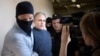 FILE - Paul Whelan, a former U.S. Marine, second left, who was arrested for alleged spying in Moscow at the end of 2018, speaks to a journalist as he escorted by Federal Security Service officers to a court room in Moscow, Russia, Aug. 23, 2019.
