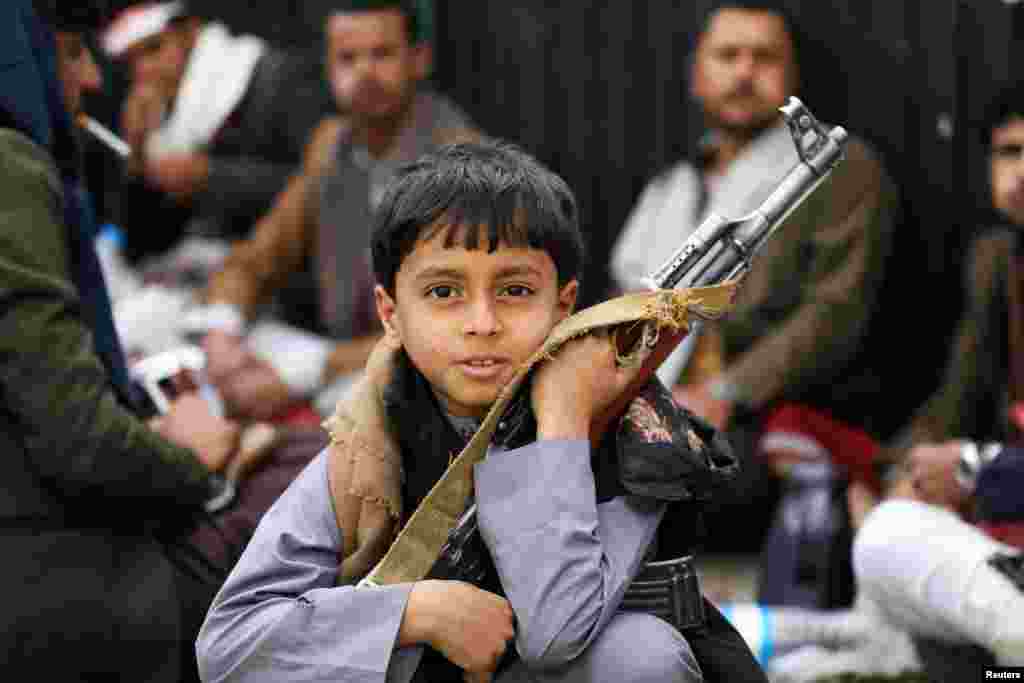 A boy holds a rifle as he attends a rally of Houthi movement supporters to mark the Ashura in Sana'a, Yemen.