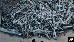 Police officers examine the collected remains of the Russian rockets that hit Kharkiv, December 3, 2022. (Libkos/AP)