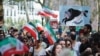 People hold placards and wave Iranian flags during a global protest in solidarity with Iranian women in New York on September 16, 2023, on the first anniversary of the death of Iranian Kurd Mahsa Amini in custody. (Photo by Kena Betancur / AFP)