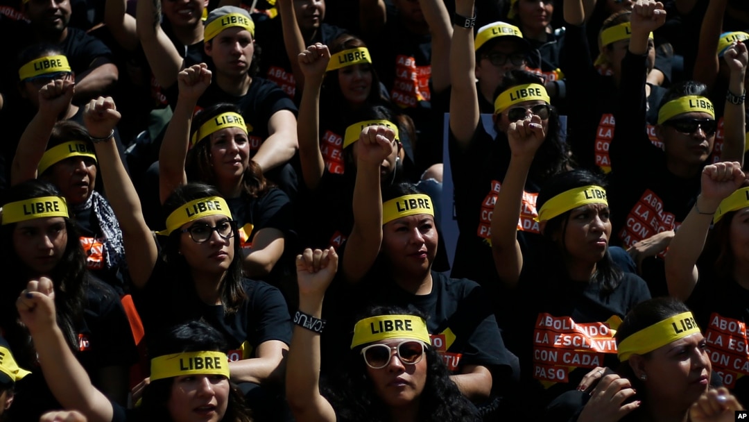 People protesting against human trafficking and slavery raise their fists during a demonstration in Mexico City, Oct. 14, 2017. Dozens of people participated in Mexico City's silent "Walk for Freedom."