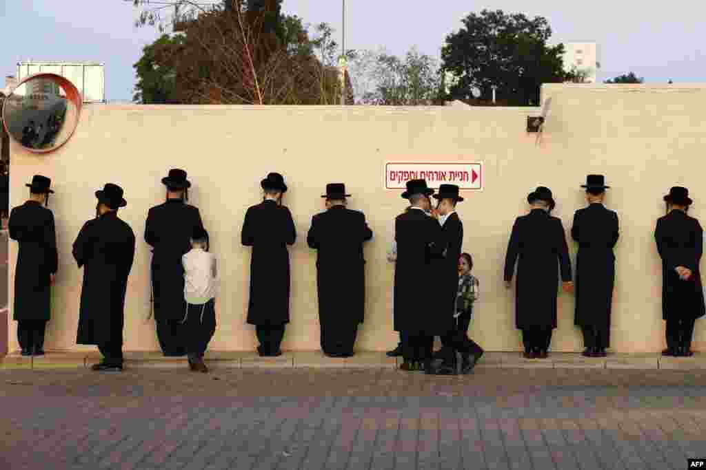 Ultra-Orthodox Jewish men pray along a wall in the Israeli city of Ramat Gan, near Tel Aviv.