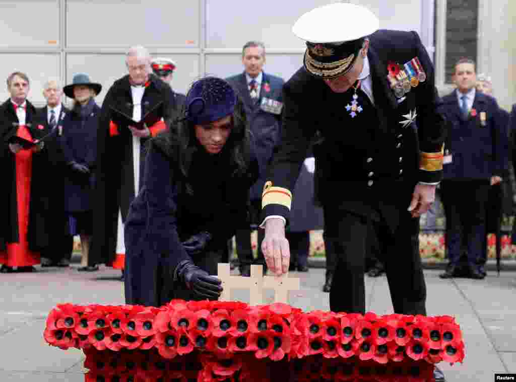 Britain’s Prince Harry and Meghan, Duchess of Sussex, place a cross during the 91st Field of Remembrance at Westminster Abbey in London.