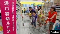 El estudio de la OMS y UNICEF pide a la industria que genera 55.000 millones cumpla con el histórico Código Internacional de Comercialización de Sustitutos de la Leche Materna de 1981. En la imagen una familia ve alimentos para bebes en un supermercado en China. [Foto de archivo]