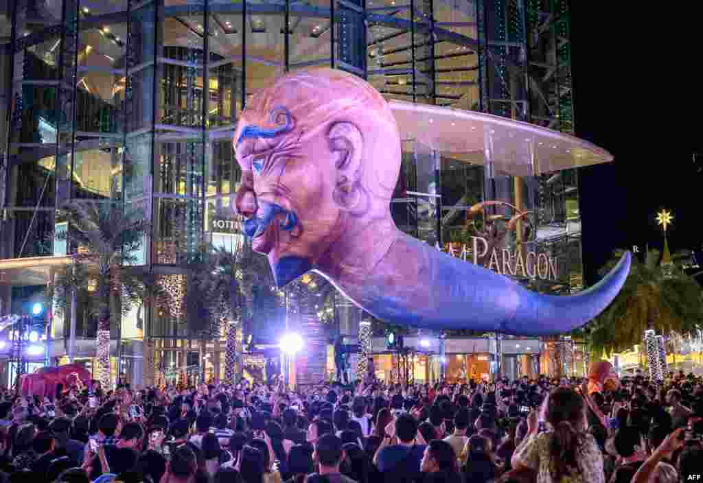 A giant balloon representing a mythical creature flies over the crowd during 'The Quest of Adventure in the World of Magical Tales' Christmas show performed by French group Plasticiens Volants in Bangkok, Thailand.