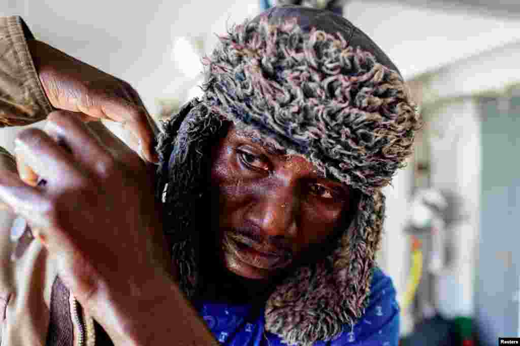 Mamoudou Doulla who sustained a gunshot wound in Libya stands onboard the NGO Proactiva Open Arms rescue boat near the Sicilian port of Augusta, Italy.
