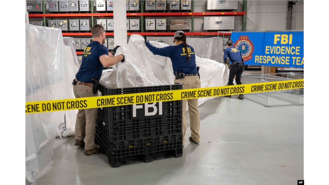 En esta imagen facilitada por el FBI, agentes asignados a un equipo especial manipulan el jueves 9 de febrero de 2023, en el laboratorio de la agencia, los materiales recuperados de un globo chino supuestamente espía que fue derribado en aguas frente a la costa de Carolina del Sur. (FBI vía AP)