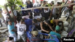 Miners try to rescue comrades trapped in a gold mine from flooding after it collapsed, near the area of El Playon, in Riosucio, Caldas province, Colombia, May 14, 2015.
