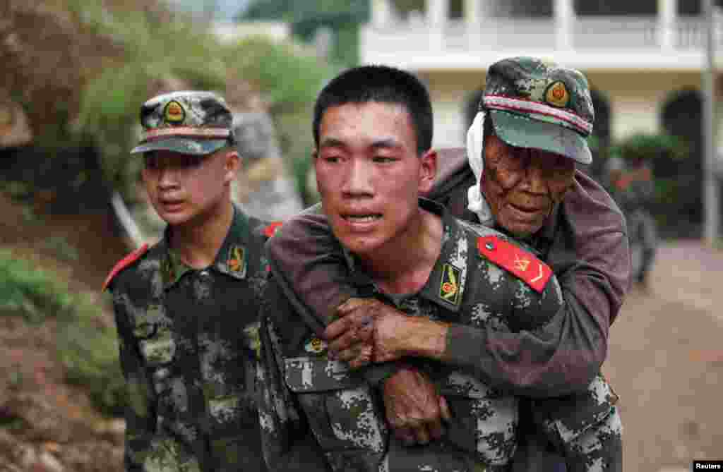A paramilitary policeman carries an elderly man on his back after an earthquake hit Ludian county of Zhaotong, Yunnan province.