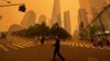 Transeúntes caminan frente al One World Trade Center en medio de la humareda por los incendios forestales de Canadá, el miércoles 7 de junio de 2023, en Nueva York. 